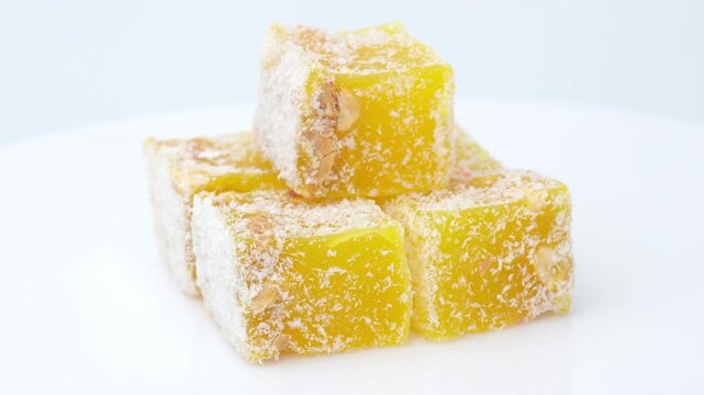 Assorted colorful Turkish delight sweets with nuts and coconut flakes rotating slowly close up. Rahat Lokum	
