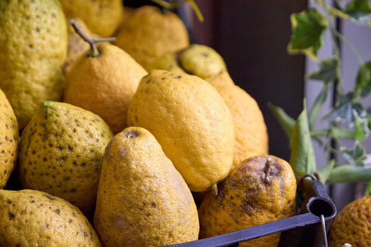 Freshly picked Sicilian lemons piled high in a market stall for sale in Taormina.