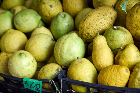 Freshly picked Sicilian lemons piled high in a market stall for sale in Taormina.