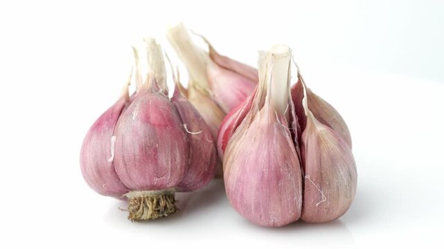 Unpeeled fresh organic garlic bulbs rotating in close up view. Harvesting and agriculture. Farming. Vegetables.	
