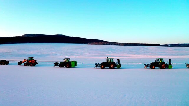 Long Winter Vehicle Convoy Traveling Beside a Snow Route