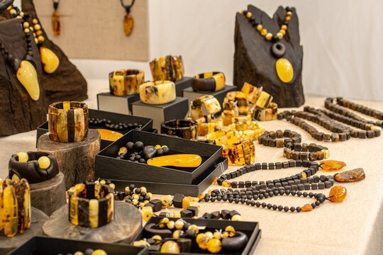 Display of handcrafted Baltic amber jewelry, featuring necklaces, bracelets and pendants in warm shades of yellow and brown