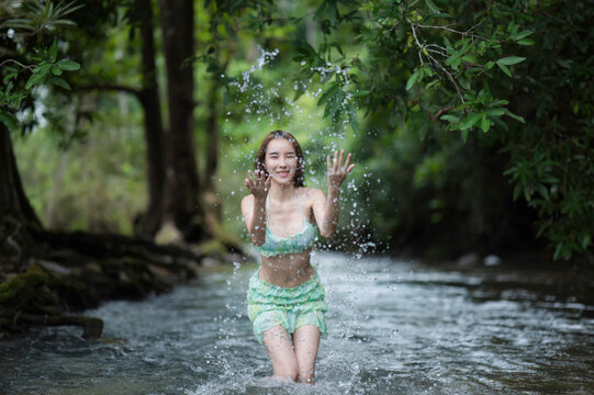 Portrait young woman in bikini with Splash water the Stream