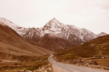 Obraz premium Scenic mountain road with snow-capped peaks