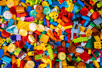 Obraz premium Top view A pile of multicolor of many Lego toy blocks in various shapes and different sizes. Toys and games. Leisure and recreation.