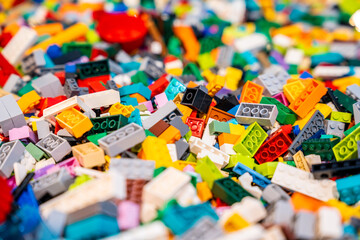 Obraz premium A pile of multicolor of many Lego toy blocks in various shapes and different sizes. Toys and games. Leisure and recreation.