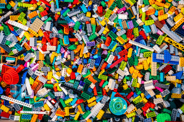 Obraz premium Top view A pile of multicolor of many Lego toy blocks in various shapes and different sizes. Toys and games. Leisure and recreation.