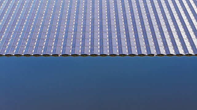Aerial view of a floating solar farm on the Lippe Gabriels Plas with rows of photovoltaic panels reflecting on the calm water surface in Ureterp, Friesland, Netherlands.