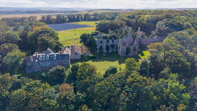 Aerial view of historical Seacliff House ruins surrounded by fields in North Berwick Scotland