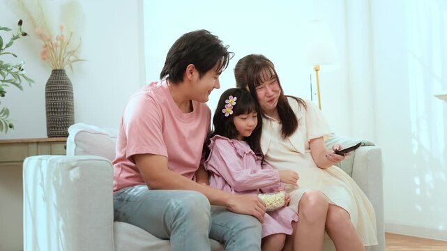 Family Enjoys Watching Television Together in a Cozy Living Room During the Afternoon