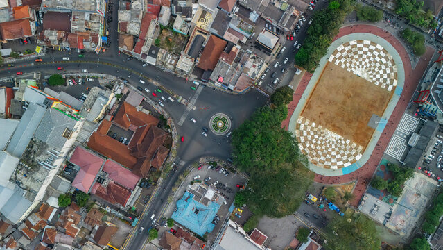 Aerial view of the Merdeka Square area in Sukabumi, featuring a distinctive checkered pattern on the ground, surrounding urban streets, and dense city buildings in Sukabumi, Indonesia.