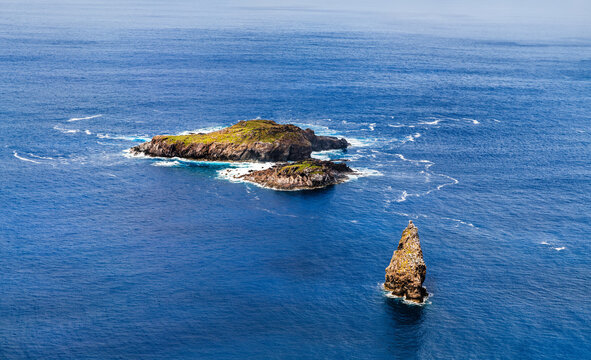 Scenic aerial view of the volcanic islets Motu Nui, Motu Iti, and Motu Kao Kao in the blue Pacific Ocean near Easter Island, Chile.
