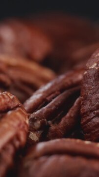 Extreme macro shot of fresh premium pecan nuts filling the frame with selective focus, rotating slowly with artistic lighting. Perfect for healthy eating, gourmet food, culinary, and dietary content.