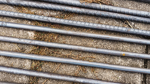 Close Up Of Steel Reinforcing Bars Laid On A Concrete Surface