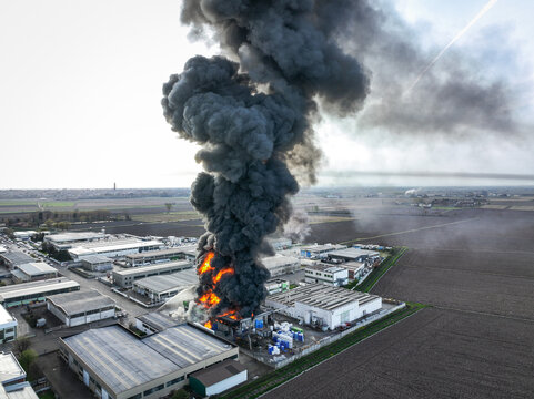 Aerial view of a column of black smoke rising from a fire at a chemical plant in an industrial area in Novara, Piedmont, Italy.