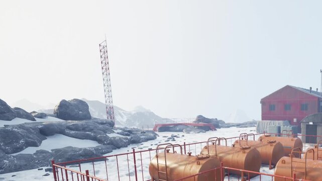 Bright snowy terrain features red buildings and tanks, surrounded by rocky outcrops. The scene captures a cold atmosphere, hinting at an industrial site.