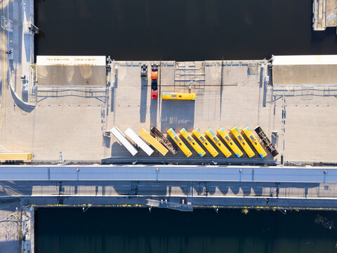 Aerial view of Vartahamnen port area with rows of yellow buses parked on the concrete dockside in Stockholm, Stockholms lan, Sweden.