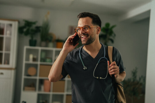 Doctor discussing healthcare on phone preparing for house call