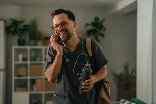 Male doctor talking on phone getting ready for work