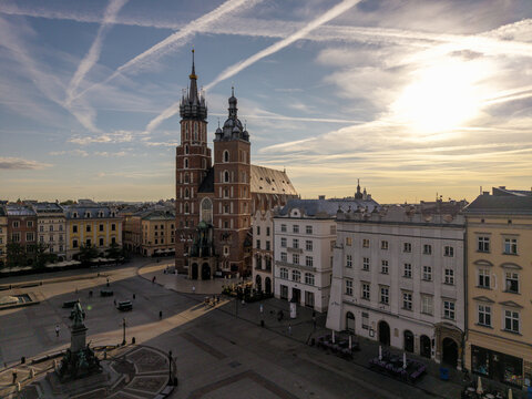 Aerial view of St. Mary's Basilica standing in the historic Main Market Square with surrounding townhouses and golden hour light in Krakow, Lesser Poland Voivode, Poland.