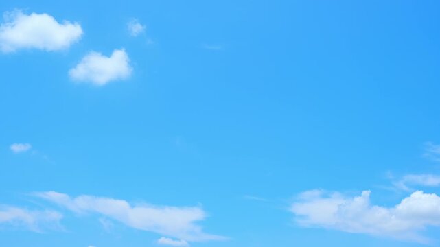 A blue sky cloud timelapse video featuring scattered cumulus humilis and wispy cirrus drifting across a vivid blue sky, capturing peaceful weather, open atmosphere, nature, and tranquil daylight.
