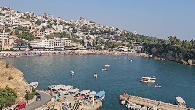 small beach and harbor in ulcinj montenegro on a sunny summer day with swimmers and city view video