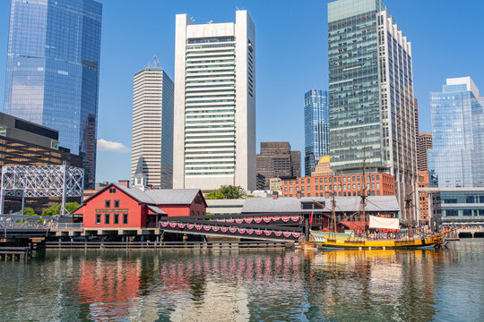 Boston, MA, US-July 11, 2026: View of the iconic Boston Tea Party Museum as from the Seaport district with skyscrapers and Fort Point Channel in foreground.