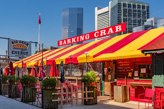Boston, MA, US-July 11, 2026: View of the iconic Barking Crab seafood restaurant the Seaport district with skyscrapers in the background.