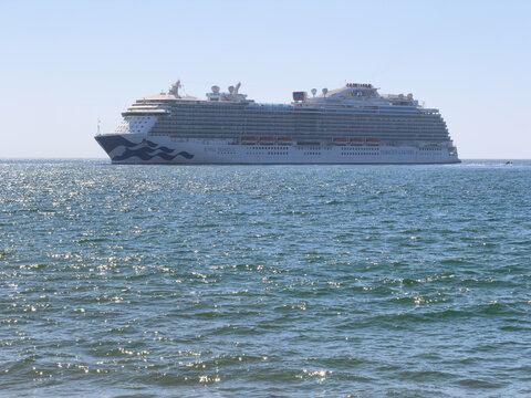 SANTA BARBARA, CA, APR 8, 2026: The Royal Princess cruise ship sails on sparkling blue water under a clear sky, with a small boat visible near its stern