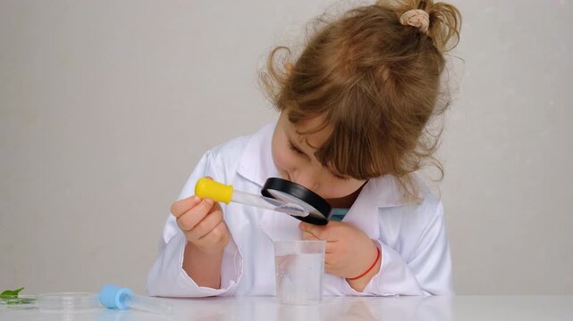 Laboratory examination of a child with test tubes, reagents and a microscope. Selective focus.