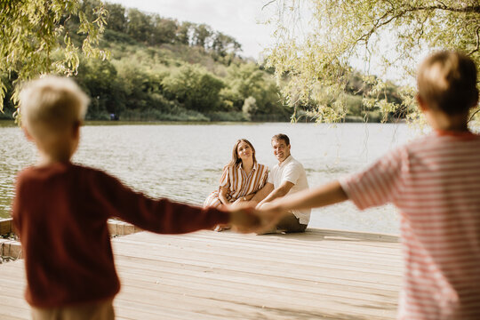 Joyful family moments by the serene lake on a sunny afternoon