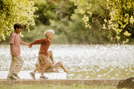 Joyful children playfully exploring a lakeside path on a sunny day