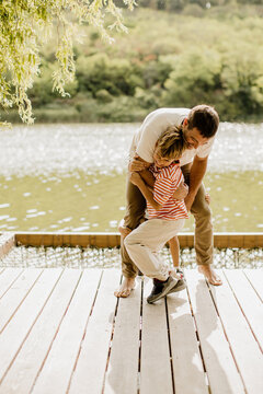 Father and son share joyful moments near a serene lake