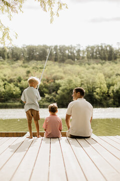 Father and children enjoying peaceful fishing by the serene lake