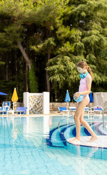 Young girl prepares to jump into the cool blue pool surrounded by nature
