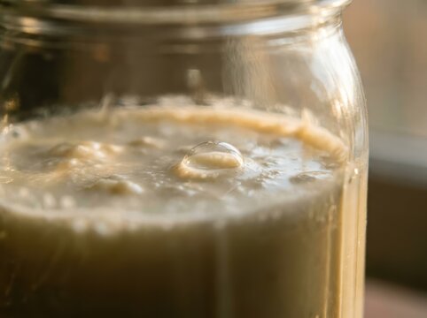 Close Up Of A Single Bubble Forming On The Surface Of Fermenting Milk, Indicating A Natural Biological Process