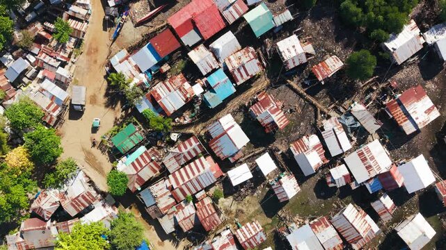 Overhead view reveals rusted roofs, muddy ground and dense coastal homes