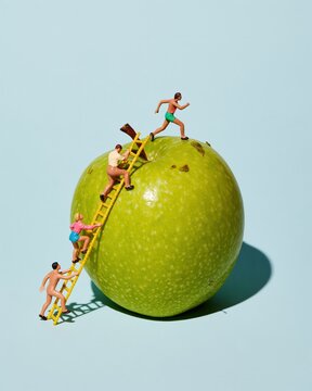 Giant green apple with tiny carved figures of kids playing and climbing for family and education campaigns, featuring bright light and copy space