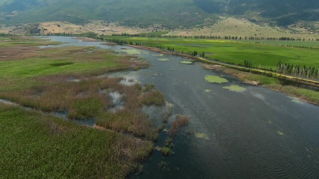 Drone footage surveys shallow pools reed beds wet meadows and natural drainage patterns across the marshland