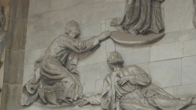 Static shot of a detailed stone bas relief carving depicting religious figures inside the Cathedral of Oviedo