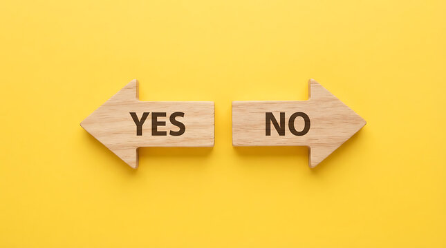 Two wooden arrows pointing in opposite directions with the words yes and no engraved on each, placed on a flat yellow background, representing decision making, choices, and binary options concept