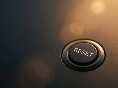 Reset button on control panel with soft lighting and dark background, symbolizing restart and fresh start in technology