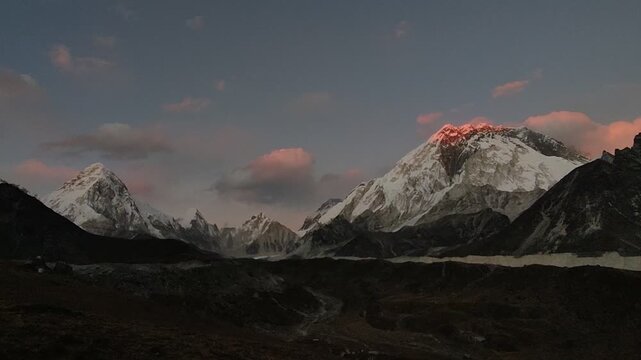 Timelapse of a dramatic Himalayan mountain landscape in Nepal, with rugged peaks and valleys changing under moving clouds and evening light.
