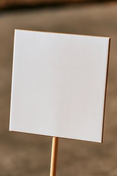 Close-up of a simple blank sign on a wooden dowel for handmade signage