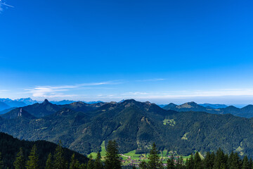 Obraz premium Stunning panorama view of peaks of Ammergebirge Alps from top of mountain Wallberg in summer on a sunny day, Miesbach, Bavaria, Germany