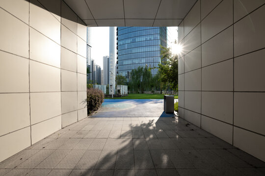 Modern city building passage with sunlight casting shadows on the ground