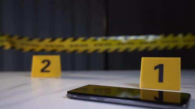 Cracked smartphone at marker one lies beside a SIM card at marker two on a marble table with police line tape in the background, tense forensic mood, rack focus shot