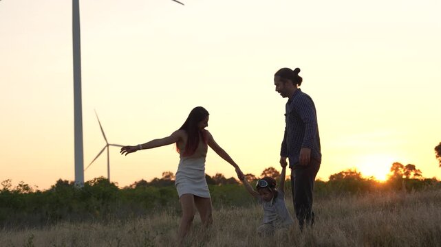 Family happiness and bonding at sunset, relaxation and renewable energy with innovation, wind turbines and sustainable energy, travel, relaxation and the environment.	
(VDO 4K)