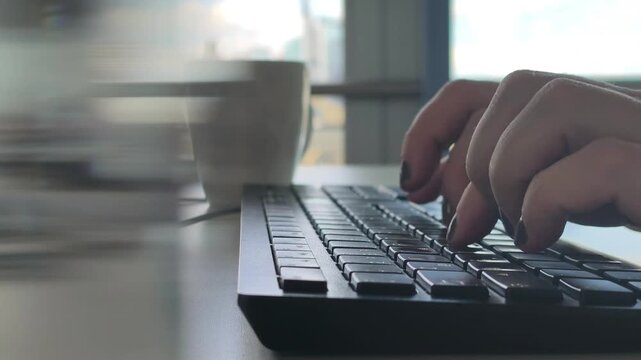Close-up of hands typing on a computer keyboard. Concept of work, technology, communication and modern digital lifestyle.