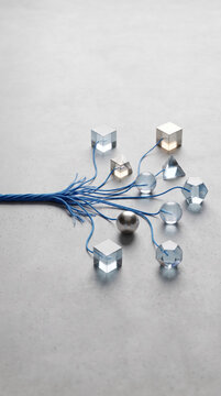Blue wire network connecting geometric metal object on gray surface, symbolizing technology, connection, and abstract data structure